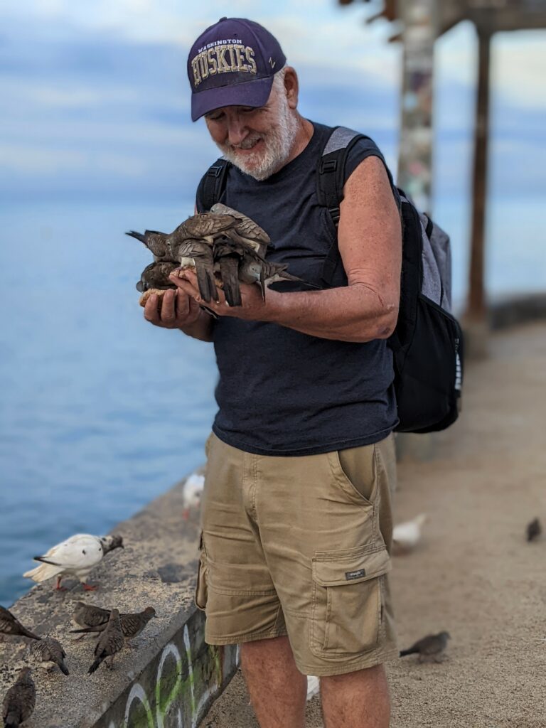 old man holding birds